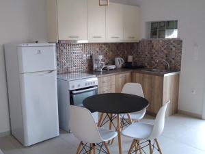 een keuken met een zwarte tafel en witte apparaten bij Κamares View (Αύρα) in Ayeranós +19 foto's