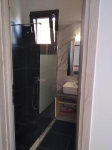 een badkamer met een douche en een wastafel bij Κamares View (Αύρα) in Ayeranós