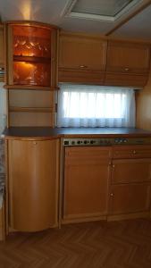 a kitchen with wooden cabinets and a counter top at Comtesse-Camping Plauer See in Brandenburg an der Havel