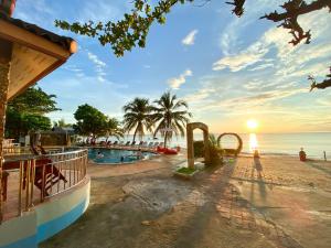 a resort swimming pool with the ocean in the background at Lanta Paradise Beach Resort in Ko Lanta