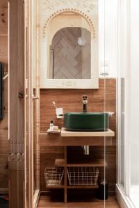 W łazience znajduje się zielona umywalka i lustro. w obiekcie Villa Milimani - stuletnia, folk & butique, adults only w Zakopanem