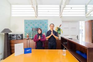 雅加達的住宿－Singgahsini Mampang Prapatan V，男人和女人站在房间里,双手站起来