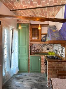 una cucina con armadi verdi e una porta verde di La terrazza sul Monferrato a Montegrosso dʼAsti