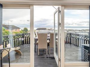 balcón con vistas a una mesa y sillas en 6 person holiday home in Tranek r en Tranekær