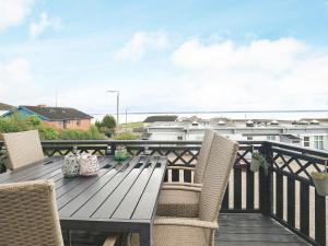 terraza con mesa de madera y sillas en el balcón en 6 person holiday home in Tranek r en Tranekær