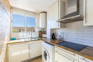 a kitchen with a sink and a washing machine at L’Ancora Suite in Jávea
