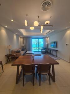 a living room with a wooden table and chairs at Luxury sea view Apartment In Address Hotel Fujairah in Fujairah