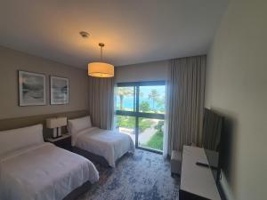 富查伊拉的住宿－Luxury sea view Apartment In Address Hotel Fujairah，酒店客房设有两张床和窗户。
