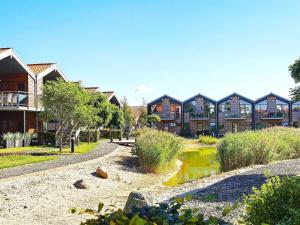 a row of houses in a park with a pond at 4 person holiday home in Bogense in Bogense