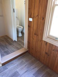 a bathroom with a toilet and a wooden door at Nunyara in Aireys Inlet