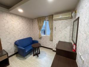 a living room with a blue chair and a table at 苓旅-站前 Lin Inn TMS in Taipei