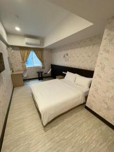 una camera con un grande letto bianco di 苓旅-站前 Lin Inn TMS a Taipei