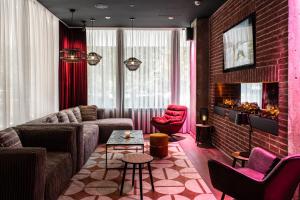 a living room with a couch and a brick wall at Pentahotel Bremen in Bremen