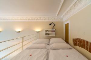 2 łóżka w pokoju z białymi ścianami i sufitem w obiekcie Urban Stuck w Berlinie