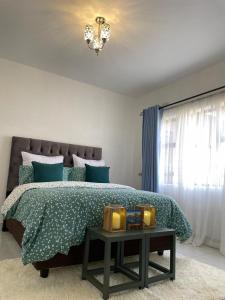 um quarto com uma cama com uma colcha verde e uma mesa em Amour de Soeurs em Norton