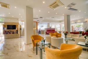 un hall avec des chaises et des tables dans un bâtiment dans l'établissement Arte hotel, à Rhodes