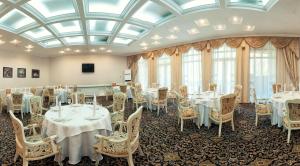een kamer met tafels en stoelen en een glazen plafond bij Chaika Gostinichny Kompleks in Karagandy