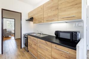 cocina con microondas y encimera en Apartman JakoDoma en Česká Lípa