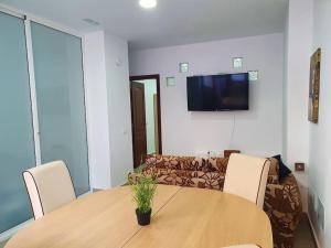 a dining room with a wooden table and a couch at Stylish one bedroom apartment near the Drago Tree in Icod de los Vinos