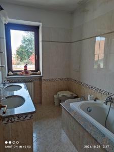 a bathroom with two sinks and a tub and a toilet at Casa mami in Sommariva del Bosco