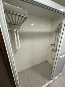 a shower with a glass door in a bathroom at 苓旅-站前 Lin Inn TMS in Taipei