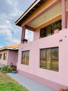 a pink house with windows and plants on it at Amour de Soeurs in Norton