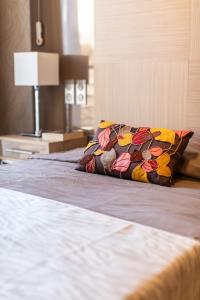 Fréjus Appart'S في فريجوس: سرير مع وسادة ملونة فوقه