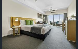 um quarto de hotel com uma cama e uma sala de estar em Pandanus em Darwin
