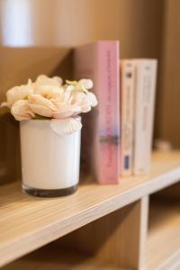 a flower in a pot on a shelf with books at Fréjus Appart'S in Fréjus