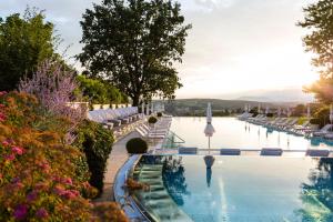 a view of a pool at a resort with flowers at Hotel & Spa Der Steirerhof in Bad Waltersdorf