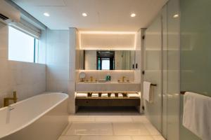 a bathroom with a tub and a sink and a mirror at Five Palm Jumeirah Dubai in Dubai
