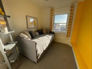 1 dormitorio con sofá y ventana en East Walls Apartment en Chichester