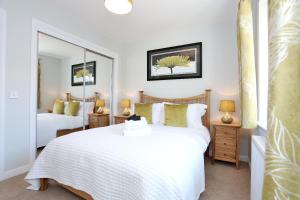 a bedroom with two beds and a mirror at Town and Country Birchlee Road Apartments in Inverurie