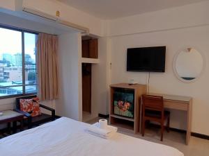 曼谷的住宿－Crown BTS Nana Hotel，酒店客房配有一张床、一张书桌和一台电视。