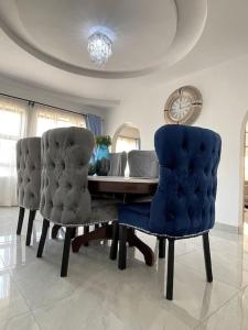 a dining room with a table and two blue chairs at Amour de Soeurs in Norton