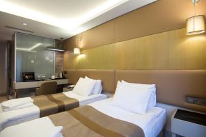 Postel nebo postele na pokoji v ubytování GK Regency Suites Hotel