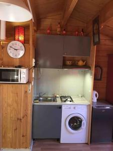 a kitchen with a stove and a washing machine at Chalet indépendant in Marseille