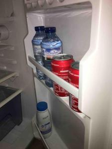 een koelkast gevuld met flessen en blikjes water bij Chalet indépendant in Marseille