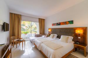 een slaapkamer met 2 bedden en een groot raam bij Khayam Garden Beach Resort & Spa in Nabeul