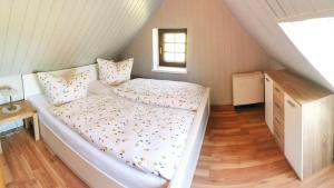 1 dormitorio con cama, escritorio y ventana en Spreewälder Schwalbenhof - Ferienhaus "Schwalbennest" en Golßen