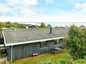 Helnæs Byにある6 person holiday home in Ebberupのベンチ付灰色の家