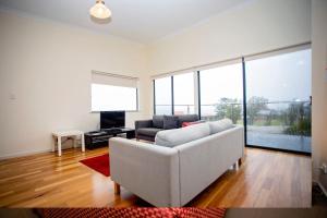 sala de estar con sofá blanco y TV en Hopetoun Motel & Chalet Village, en Hopetoun