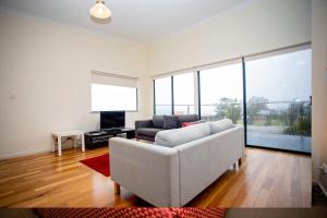 a living room with a white couch and a television at Hopetoun Motel & Chalet Village in Hopetoun