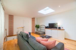 a living room with a couch and a tv at Urban Duplex in Berlin