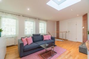 een woonkamer met een blauwe bank en roze kussens bij Urban Duplex Kreuzberg in Berlijn