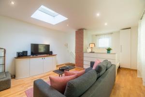 een woonkamer met een bank en een tv bij Urban Duplex Kreuzberg in Berlijn +20 foto's