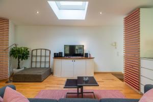 een woonkamer met een bank en een tv bij Urban Duplex Kreuzberg in Berlijn