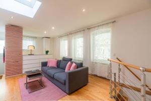 a living room with a blue couch and pink pillows at Urban Duplex in Berlin