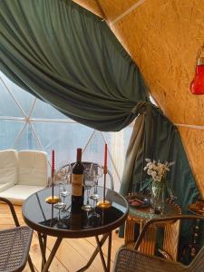 a table with a bottle of wine and wine glasses at Paradise Inn in Batumi