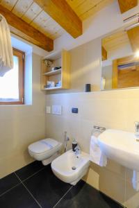 a bathroom with a white toilet and a sink at Hotel Aigle in Courmayeur